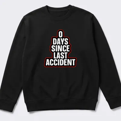 Humorous T-shirt with bold typography stating '0 DAYS SINCE LAST ACCIDENT' in black, white, and red — printed on a unisex sweatshirt