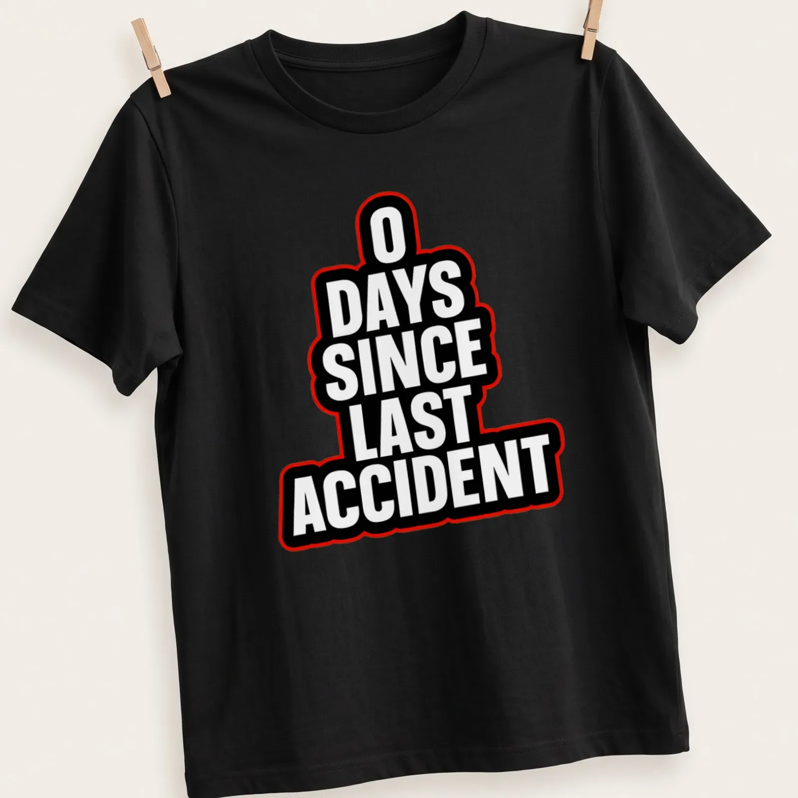 Humorous T-shirt with bold typography stating '0 DAYS SINCE LAST ACCIDENT' in black, white, and red — printed on a unisex t-shirt