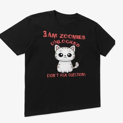 Cute cartoon cat t-shirt with pink and black text about late-night zoomies — printed on a unisex t-shirt (angled view)