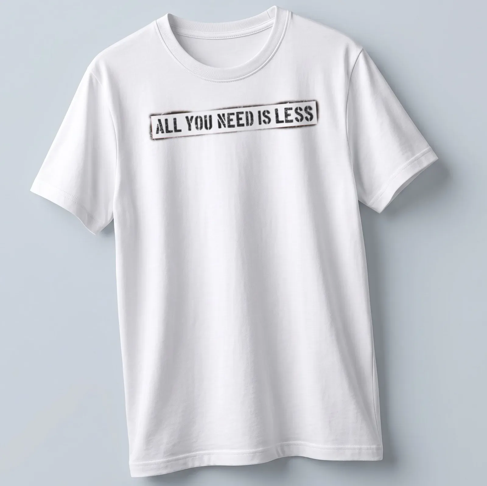 Bold distressed motivational quote t-shirt stating 'All You Need Is Less' in black, white, and red. — printed on a unisex t-shirt