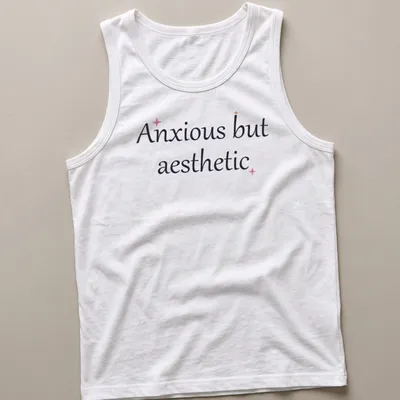 Cute mental health quote in cursive: Anxious but aesthetic, in black, pink, and gold. — printed on a tank top