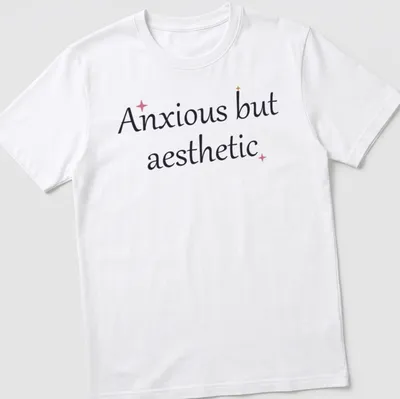 Cute mental health quote in cursive: Anxious but aesthetic, in black, pink, and gold. — printed on a unisex t-shirt