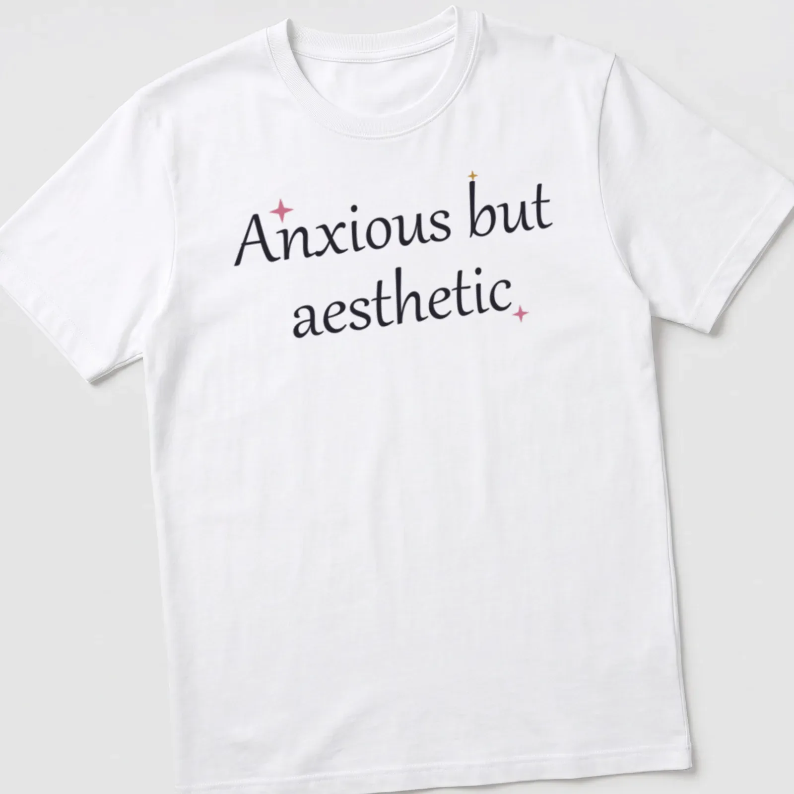 Cute mental health quote in cursive: Anxious but aesthetic, in black, pink, and gold. — printed on a unisex t-shirt