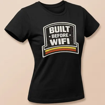 Retro humor t-shirt with 'BUILT BEFORE WIFI' in a badge design — printed on a women's shirt
