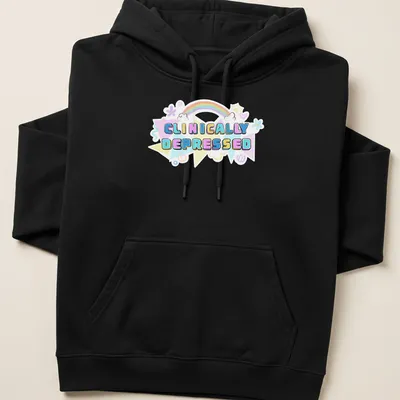 Kawaii T-shirt featuring rainbow design and the text 'CLINICALLY DEPRESSED' in pastel colors — printed on a unisex hoodie
