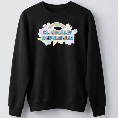 Kawaii T-shirt featuring rainbow design and the text 'CLINICALLY DEPRESSED' in pastel colors — printed on a unisex sweatshirt