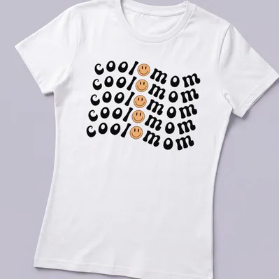 Bold playful Cool Mom T-shirt with smiley face graphic in black, yellow, and peach — printed on a women's shirt