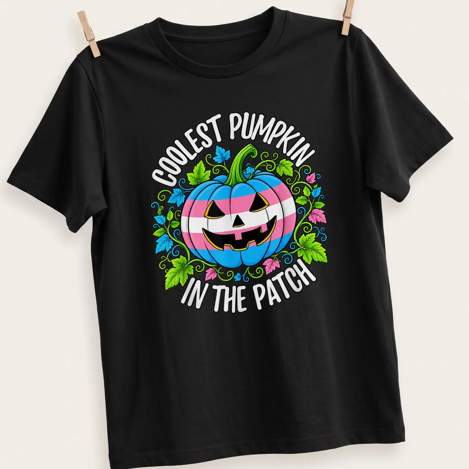Cartoonish pumpkin design with colorful Trans pride colors and playful text — printed on a unisex t-shirt