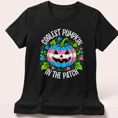 Cartoonish pumpkin design with colorful Trans pride colors and playful text — printed on a women's shirt