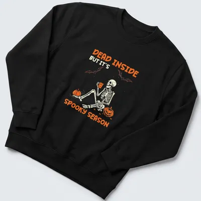 A playful skeleton surrounded by pumpkins with Halloween-themed text — printed on a unisex sweatshirt