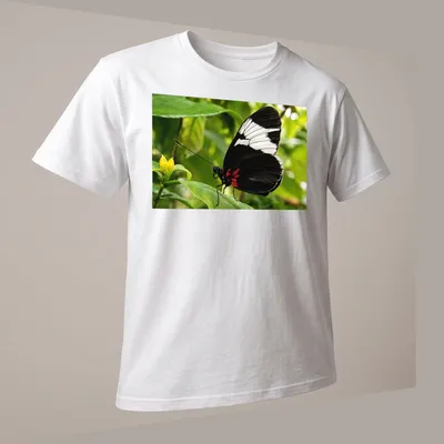 Realistic print of a Sapho Longwing Butterfly resting on a green leaf — printed on a unisex t-shirt (angled view)