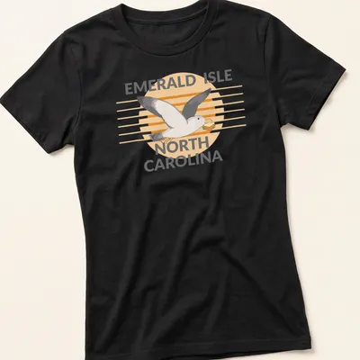 Illustrative design featuring a seagull carrying a sandwich with the text Emerald Isle North Carolina — printed on a women's shirt