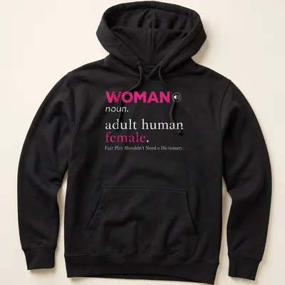 Bold typography design stating 'WOMAN noun. adult human female. Fair Play Shouldn't Need a Dictionary.' — printed on a unisex hoodie