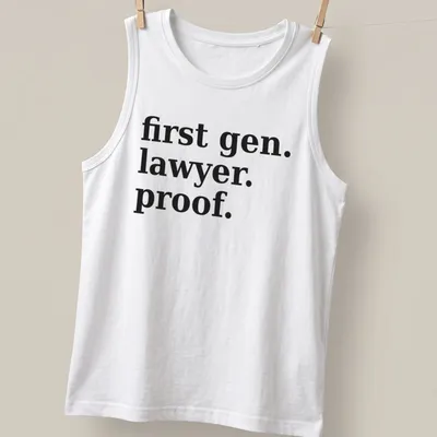 Bold typography t-shirt celebrating first-generation lawyers with black text on white background — printed on a tank top
