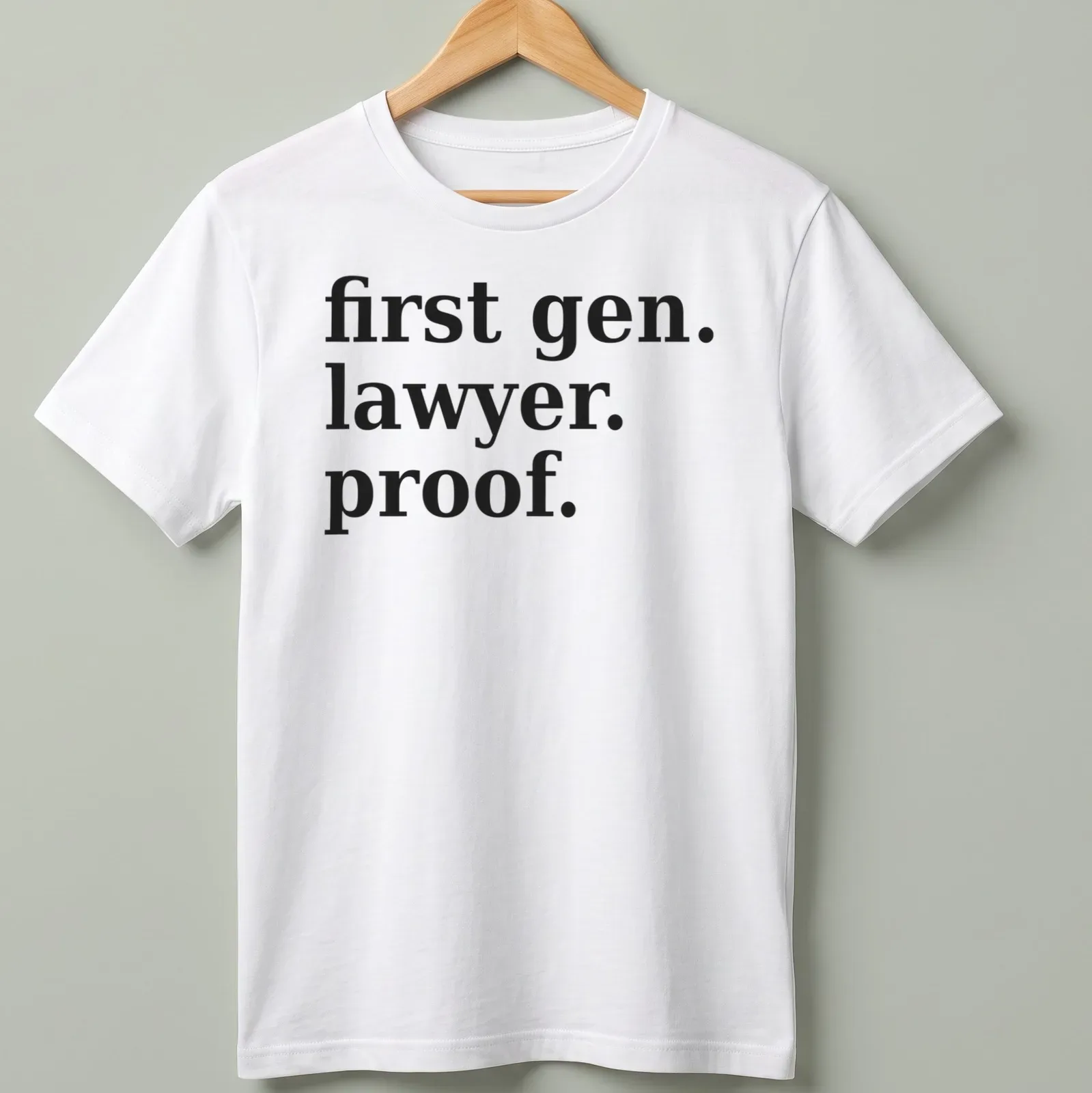 Bold typography t-shirt celebrating first-generation lawyers with black text on white background — printed on a unisex t-shirt