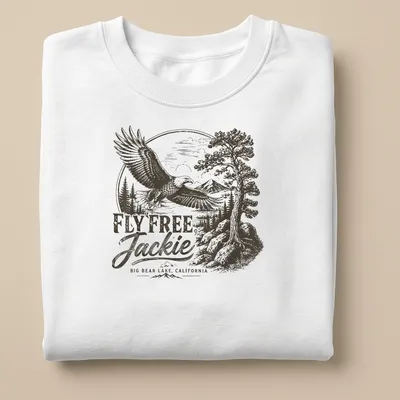 Vintage eagle graphic with text reading 'FLY FREE, Jackie BIG BEAR LAKE, CALIFORNIA' in black, white, and gray — printed on a unisex sweatshirt
