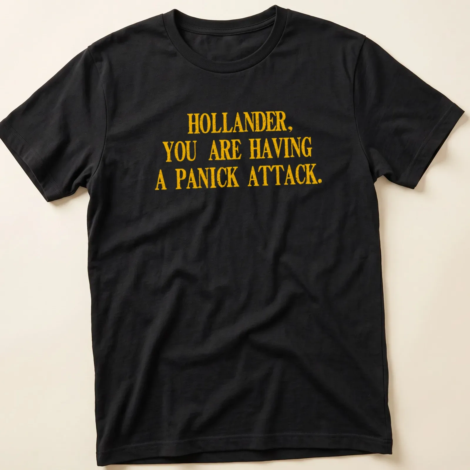 Bold distressed text reading 'HOLLANDER, YOU ARE HAVING A PANICK ATTACK' in yellow — printed on a unisex t-shirt
