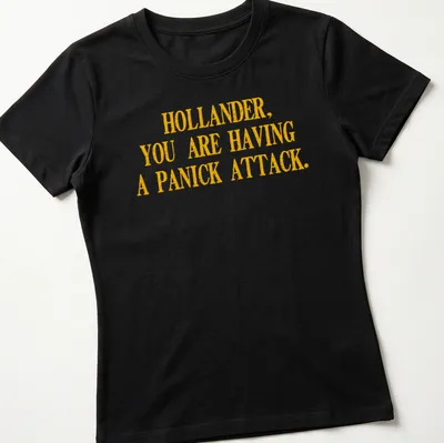 Bold distressed text reading 'HOLLANDER, YOU ARE HAVING A PANICK ATTACK' in yellow — printed on a women's shirt