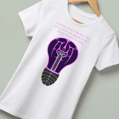 Illustration of a light bulb with motivational text in purple, black, pink, and white — printed on a women's shirt