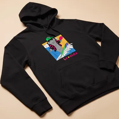 Cartoon manatee surfing with colorful waves under the text I ❤️ VACATION Leonida — printed on a unisex hoodie