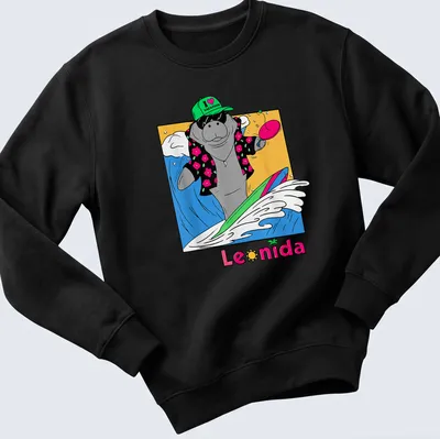 Cartoon manatee surfing with colorful waves under the text I ❤️ VACATION Leonida — printed on a unisex sweatshirt