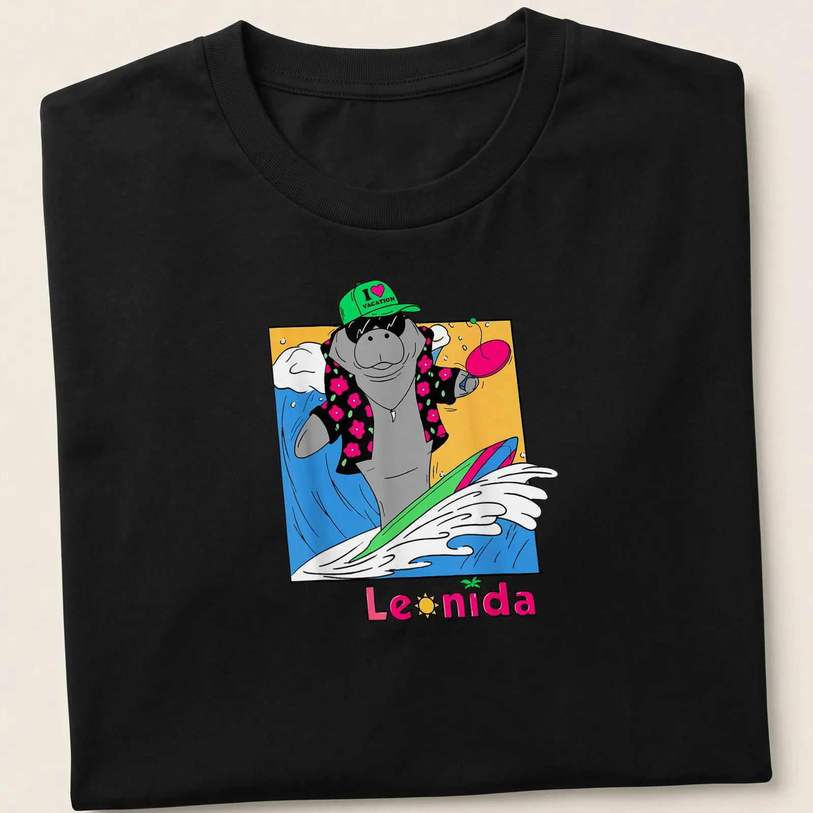 Cartoon manatee surfing with colorful waves under the text I ❤️ VACATION Leonida — printed on a unisex t-shirt