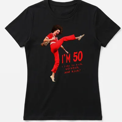 Funny 50th birthday T-shirt featuring a character kicking with humorous text — printed on a women's shirt