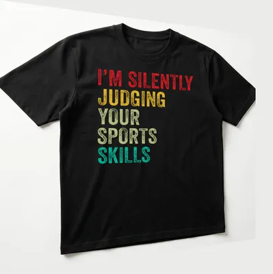 Colorful typography design stating 'I'm Silently Judging Your Sports Skills' in bold letters. — printed on a unisex t-shirt (angled view)