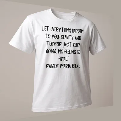Inspirational quote by Rainer Maria Rilke in handwritten script on a white — printed on a unisex t-shirt (angled view)
