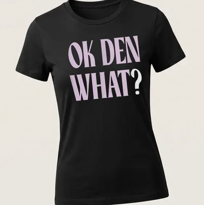 Light purple t-shirt with bold printed text saying OK DEN WHAT — printed on a women's shirt