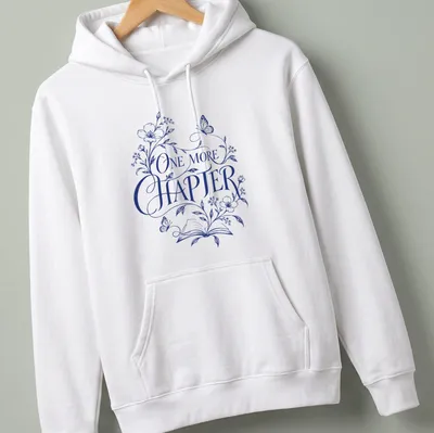 Elegant botanical design featuring an open book with flowers and butterflies, and 'One More Chapter' text — printed on a unisex hoodie