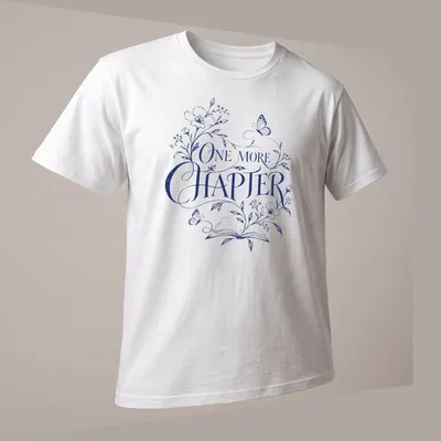 Elegant botanical design featuring an open book with flowers and butterflies, and 'One More Chapter' text — printed on a unisex t-shirt (angled view)