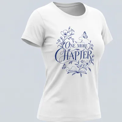 Elegant botanical design featuring an open book with flowers and butterflies, and 'One More Chapter' text — printed on a women's shirt