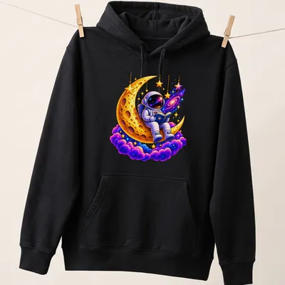 Cartoon astronaut reading on a colorful golden crescent moon — printed on a unisex hoodie