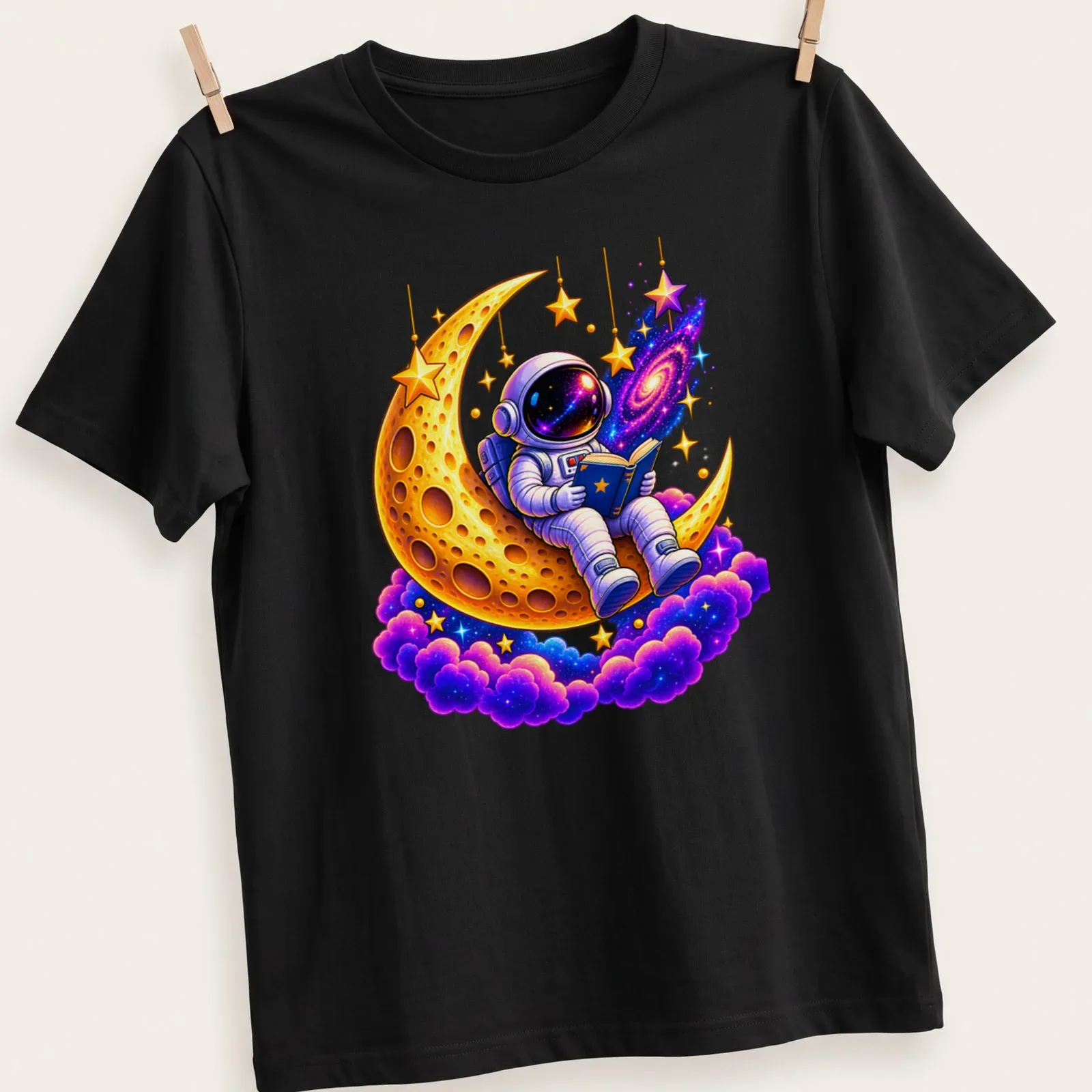Cartoon astronaut reading on a colorful golden crescent moon — printed on a unisex t-shirt