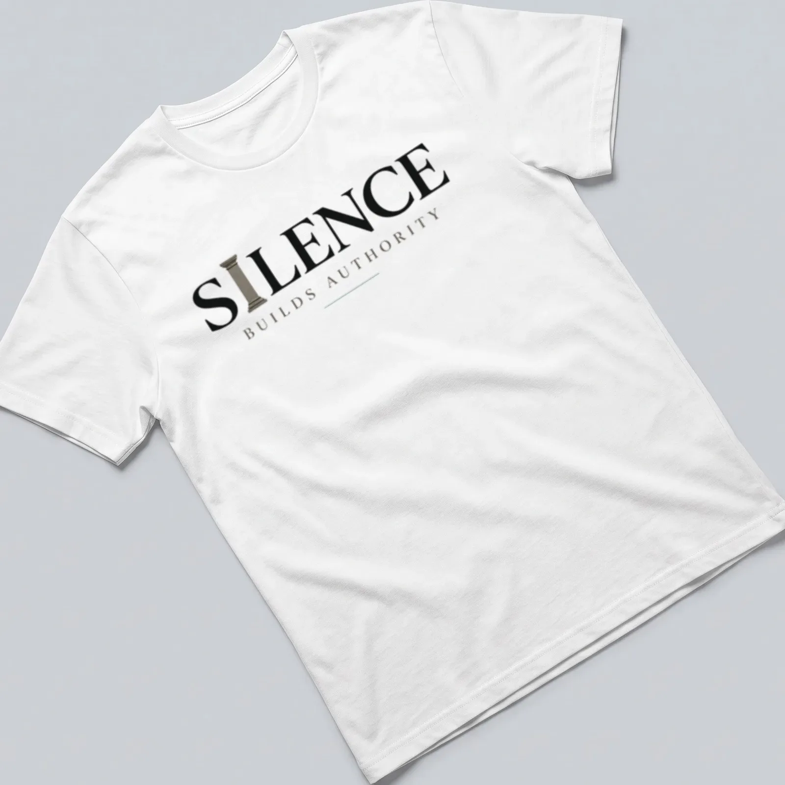 Minimal typography quote t-shirt with the phrase 'Silence Builds Authority' in black and gray text — printed on a unisex t-shirt
