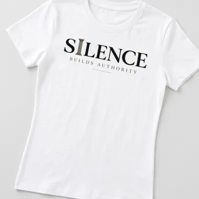 Minimal typography quote t-shirt with the phrase 'Silence Builds Authority' in black and gray text — printed on a women's shirt