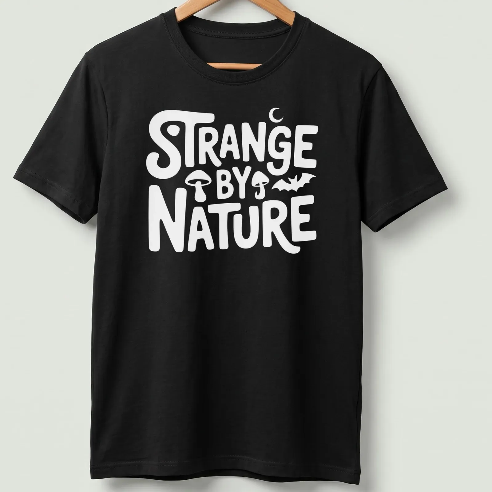 Colorful nature scene t-shirt featuring the text 'Strange By Nature' above an illustration. — printed on a unisex t-shirt
