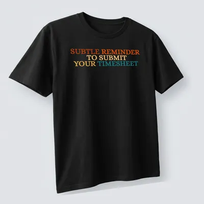 Bold colorful shirt featuring the text 'SUBTLE REMINDER TO SUBMIT YOUR TIMESHEET' — printed on a unisex t-shirt (angled view)