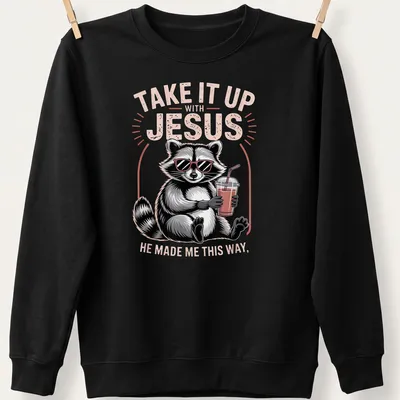Cartoon raccoon holding a drink with humorous text about Jesus — printed on a unisex sweatshirt