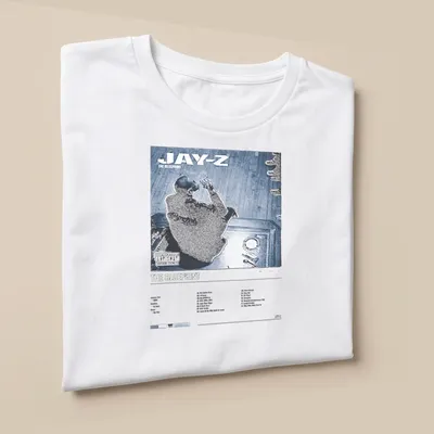 Jay-Z album cover graphic on a T-shirt featuring bold text and colors — printed on a unisex t-shirt (angled view)