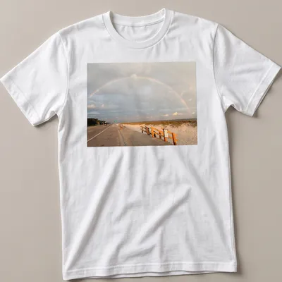Illustration of a rainbow over a beach landscape with blue and green hues. — printed on a unisex t-shirt