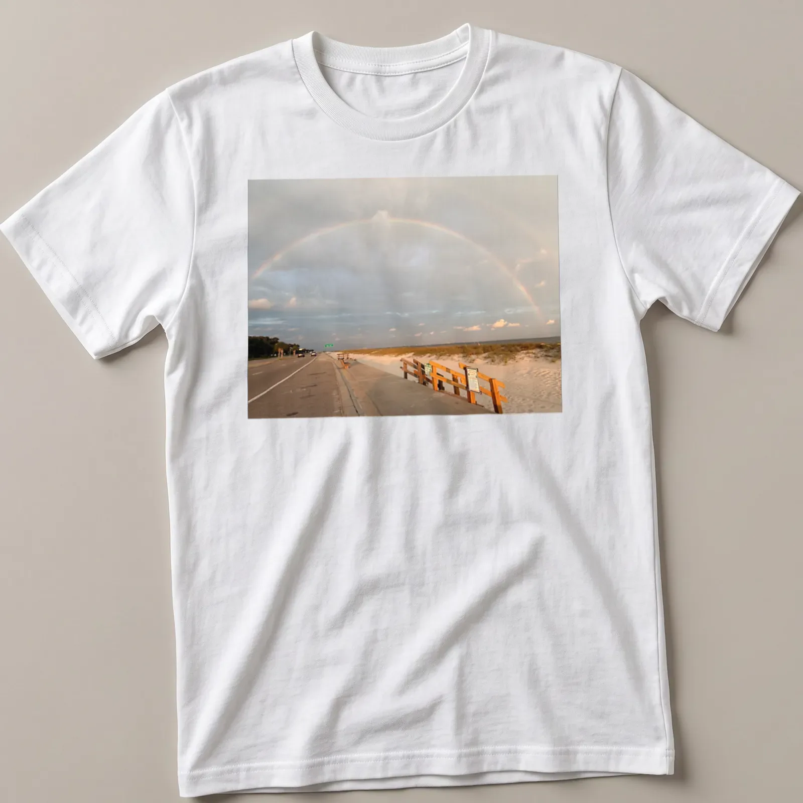 Illustration of a rainbow over a beach landscape with blue and green hues. — printed on a unisex t-shirt