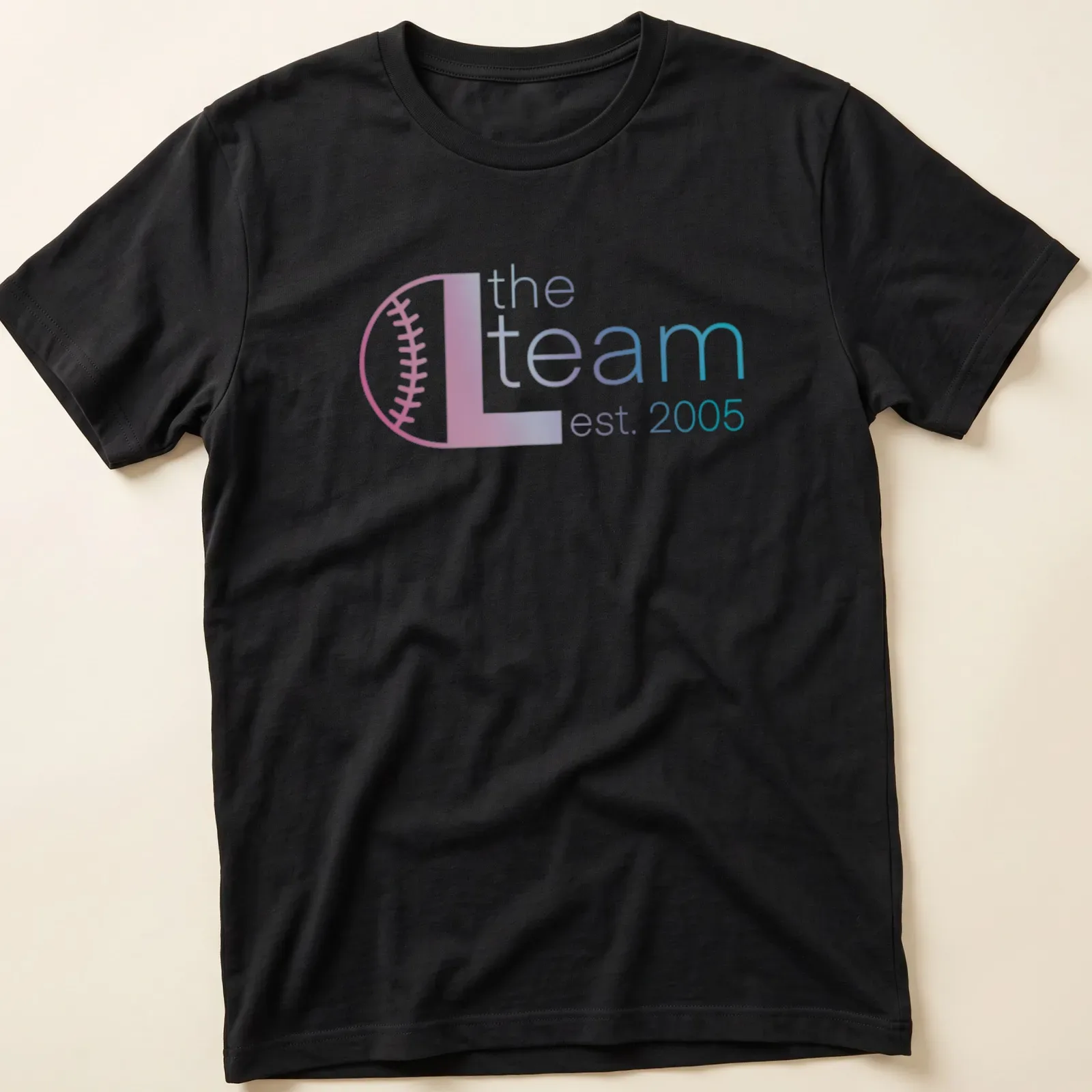 Modern gradient design with text 'the L team est. 2005' in pink, blue, and white — printed on a unisex t-shirt