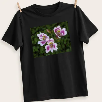 Realistic floral design featuring pink, white, green, and yellow flowers with the text 'Three Beauties' — printed on a unisex t-shirt