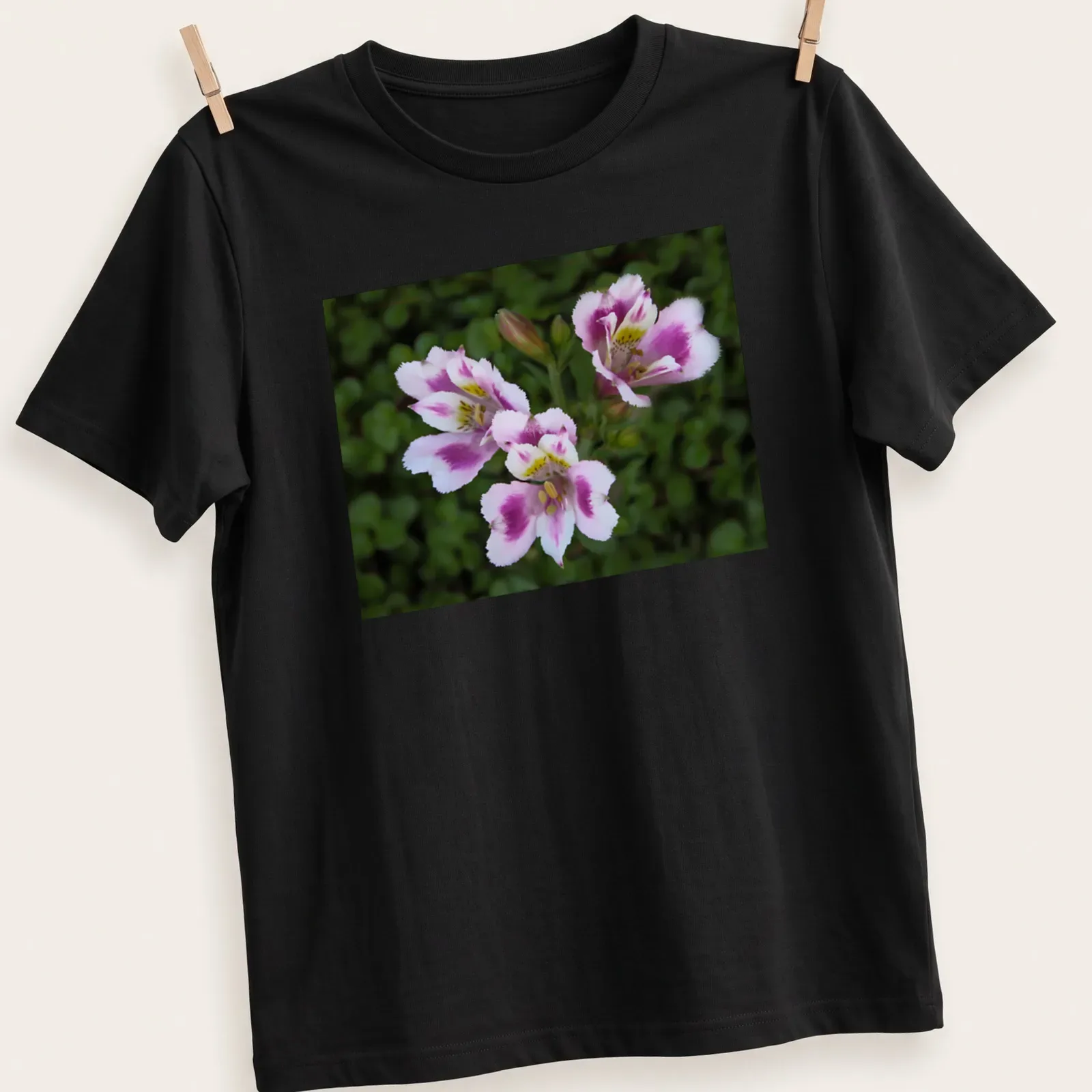 Realistic floral design featuring pink, white, green, and yellow flowers with the text 'Three Beauties' — printed on a unisex t-shirt