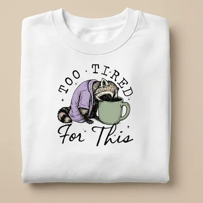 Vintage illustration of a raccoon face down in a coffee cup with playful text — printed on a unisex sweatshirt