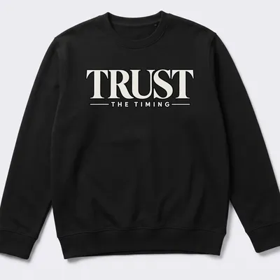 Bold typography shirt featuring the motivational quote 'Trust The Timing' in black and white — printed on a unisex sweatshirt
