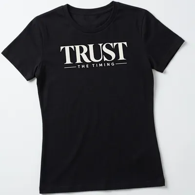 Bold typography shirt featuring the motivational quote 'Trust The Timing' in black and white — printed on a women's shirt