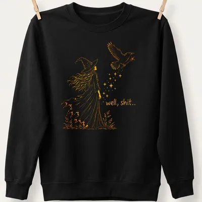 Line-art design featuring a witch and crow with the text 'well, shit..' in orange — printed on a unisex sweatshirt